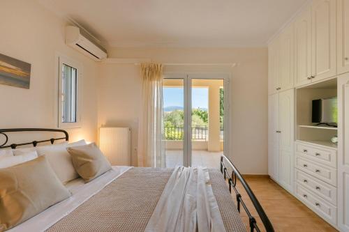 a white bedroom with a bed and a television at G&S Family Resort in Argostoli