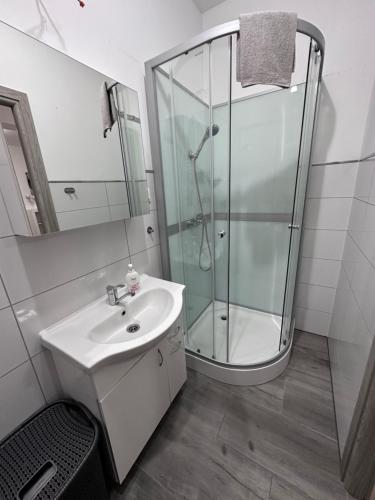 a bathroom with a glass shower and a sink at Apartament Szczecinek in Szczecinek