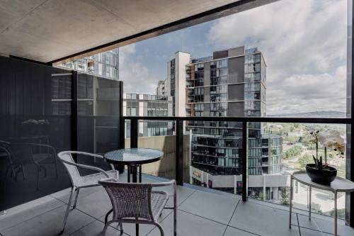 ベルコナンにあるBeautiful 2 BR Lakeside Viewのテーブルと椅子があり、街の景色が見えるバルコニー