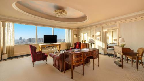 a large living room with a desk and a television at Mövenpick Hotel Al Khobar in Al Khobar