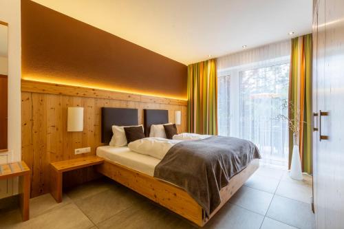 a bedroom with a large bed and a large window at Apart-Elisabeth in Mieming