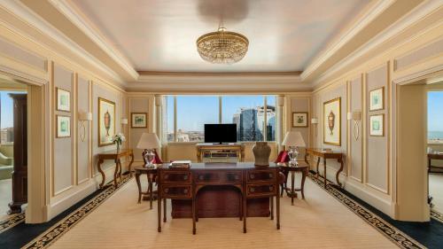 a living room with a desk and a television at Mövenpick Hotel Al Khobar in Al Khobar