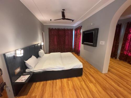 a bedroom with a large bed and a television at Silk Route in Srinagar