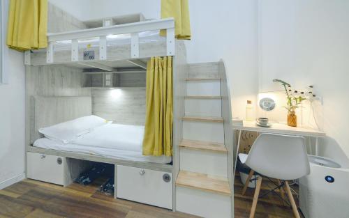 a bunk bed with a desk and a chair in a room at 笑脸里青年旅舍宽窄店 in Chengdu