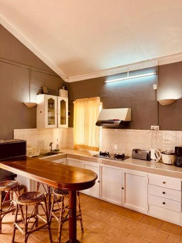a kitchen with a wooden table and some chairs at Baleau Villa in Pereybere