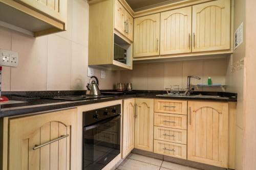 a kitchen with wooden cabinets and a sink at ATKV Klein-Kariba in Bela-Bela