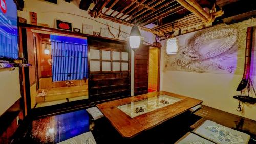a large bathroom with a wooden table and a tub at Yadoya in Kyoto