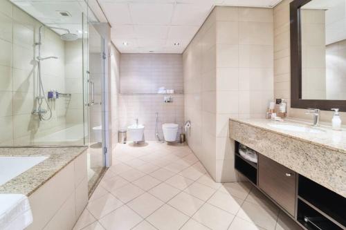 bagno con 2 lavandini, doccia e servizi igienici di FIRST CLASS 1BR Anantara The Palm Hotel a Dubai