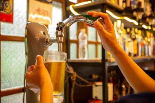 a person is pouring a glass of beer at Phong Nha Farmstay in Phong Nha