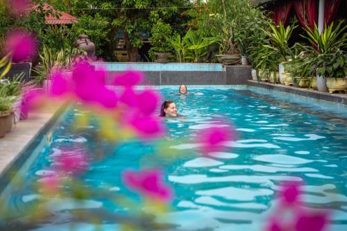 a child swimming in a swimming pool with pink toys at Phong Nha Farmstay in Phong Nha
