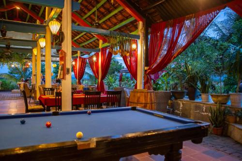a pool table in front of a restaurant at Phong Nha Farmstay in Phong Nha