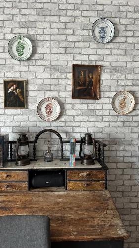 une cuisine avec un évier et des assiettes sur un mur de briques dans l'établissement La Maison des Sortilèges, à Perpignan