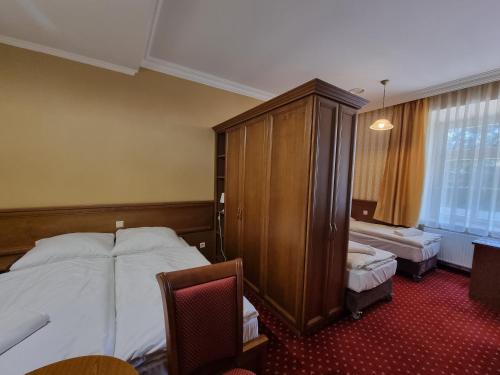 a hotel room with a bed and a chair at Pałac Lucja BB in Zakrzów