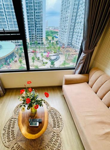 een woonkamer met een bank en een tafel met bloemen bij AN Homes in Hanoi