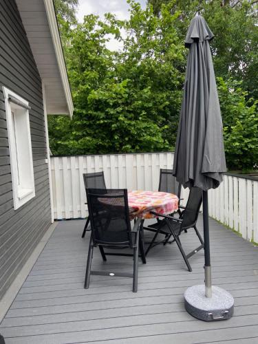 a table and chairs and an umbrella on a porch at VillaAttefall in Färjestaden