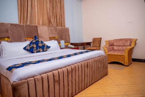 a bedroom with a large bed and a chair at The Okaseni Lodge in Arusha