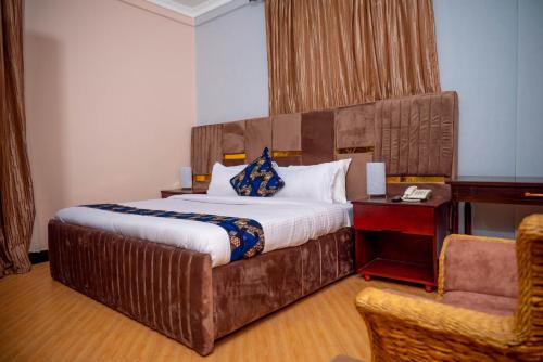 a bedroom with a large bed with a wooden headboard at The Okaseni Lodge in Arusha