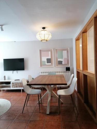 a dining room with a wooden table and white chairs at Casa Don Jaime in Magaña
