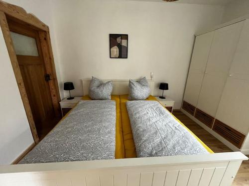 two beds in a room with two lamps and a door at Ferienwohnung zur Parthe in Grimma