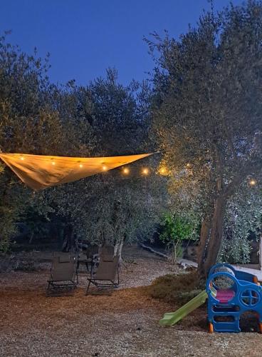 a backyard with two chairs and a canopy with lights at Il Boschetto in Santo Spirito