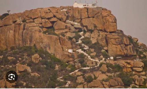 a rocky mountain with a river on top of it at ANU HOMESTAY in Hampi