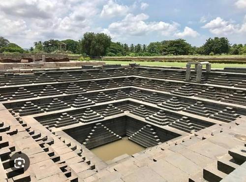 a large amphitheater with water in the middle at ANU HOMESTAY in Hampi