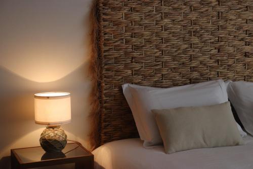 a bedroom with a bed with a lamp on a night stand at Pé n' Areia Beach House Porto Santo in Porto Santo