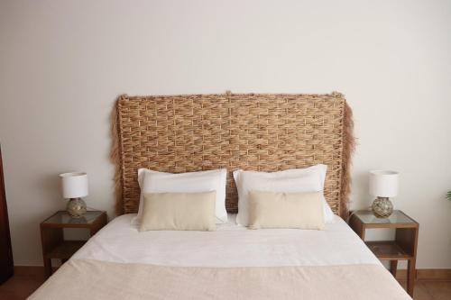 a bedroom with a large bed with two night stands at Pé n' Areia Beach House Porto Santo in Porto Santo