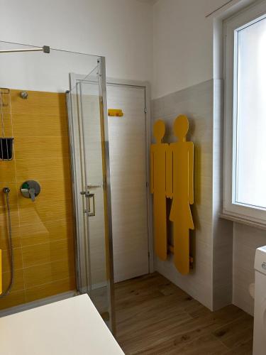 a bathroom with a shower with a yellow sign on the wall at Casammare faro e sole in Vieste