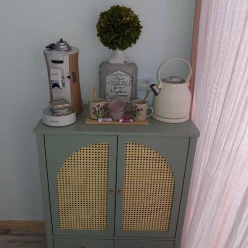 un meuble avec des tasses et un vase en haut dans l'établissement Chambre Parenthèse Cosy et institut, à Neufmarché