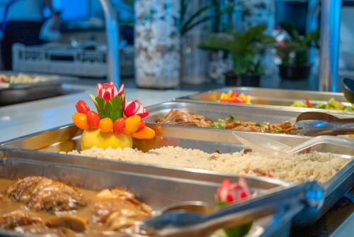 a buffet with several trays of food on a table at Lardos Bay Hotel in Lardos