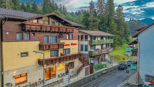 a group of buildings on a street with trees at Klass Predeal in Predeal