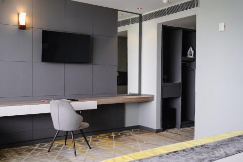 a room with a desk and a chair and a television at Manhattan Business Hotel, Male in Male City