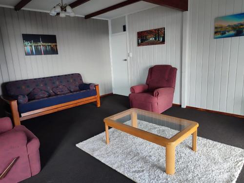 a living room with a couch and two chairs and a coffee table at Home with sea views in New Plymouth