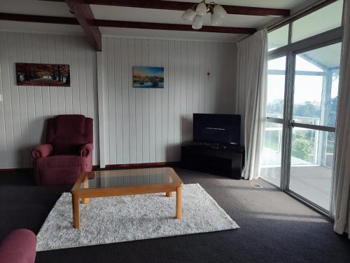 a living room with a coffee table and a tv at Home with sea views in New Plymouth
