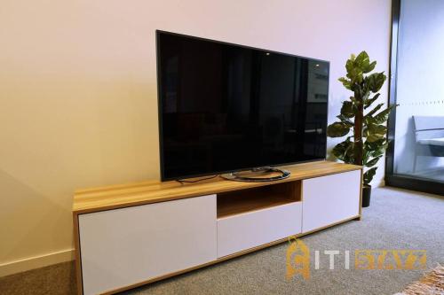 a flat screen tv sitting on top of a white entertainment center at 2bd 2bth - Chic Apt in Woden CBD in Phillip