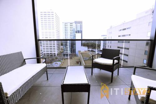 a balcony with chairs and tables on a building at 2bd 2bth - Chic Apt in Woden CBD in Phillip
