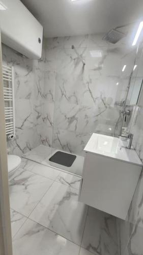 une salle de bain blanche avec un lavabo et des toilettes dans l'établissement 2 pièces,à 4 min a pieds de la mer, à Cagnes-sur-Mer