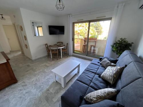 un salon avec un canapé bleu et une table dans l'établissement 2 pièces,à 4 min a pieds de la mer, à Cagnes-sur-Mer