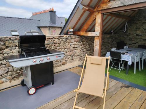 a barbecue grill on a patio with a table at La Passerelle de la Baie in Roz-sur-Couesnon