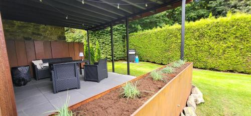 a patio with a table and chairs under a pavilion at L'Essentiel à Francorchamps in Francorchamps