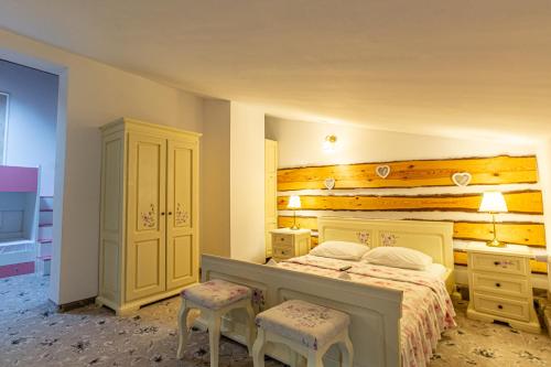 a bedroom with a bed and two stools in it at Klass Predeal in Predeal