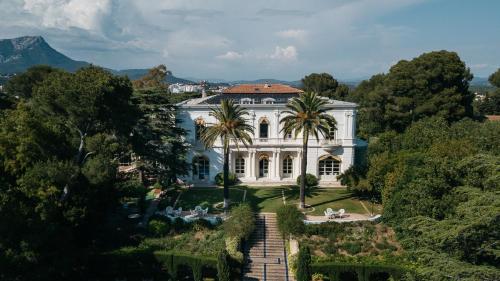 une vue aérienne d'un grand manoir blanc avec des palmiers dans l'établissement Room dhte in an exceptional villa, au Pradet