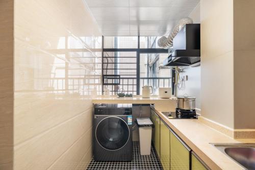 a kitchen with a washing machine in the counters at Guangzhou He She Art Apartment in Guangzhou