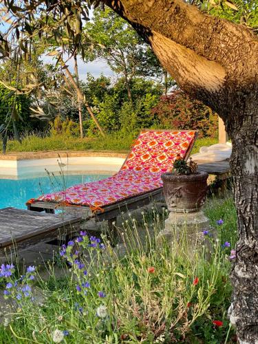 a bed sitting next to a pool next to a tree at Domaine de la Serve in Lancié