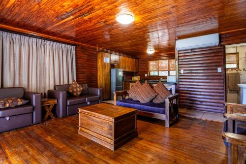 a living room with two couches and a table at ATKV Klein-Kariba in Bela-Bela