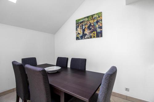a dining room table with chairs and a painting on the wall at Sweet-Gerson, calme, proche gare, parking privé in Roeser
