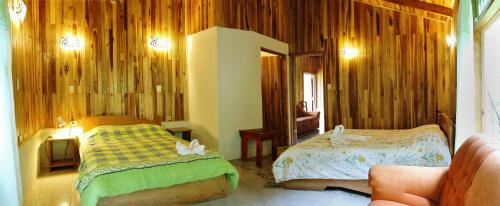 a bedroom with two beds and a mirror at Cabañas La Pradera in Monteverde Costa Rica