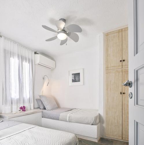 a bedroom with two beds and a ceiling fan at Kea Beachhouse in Koundouros