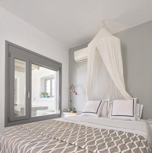a bedroom with a large bed with a window at Kea Beachhouse in Koundouros